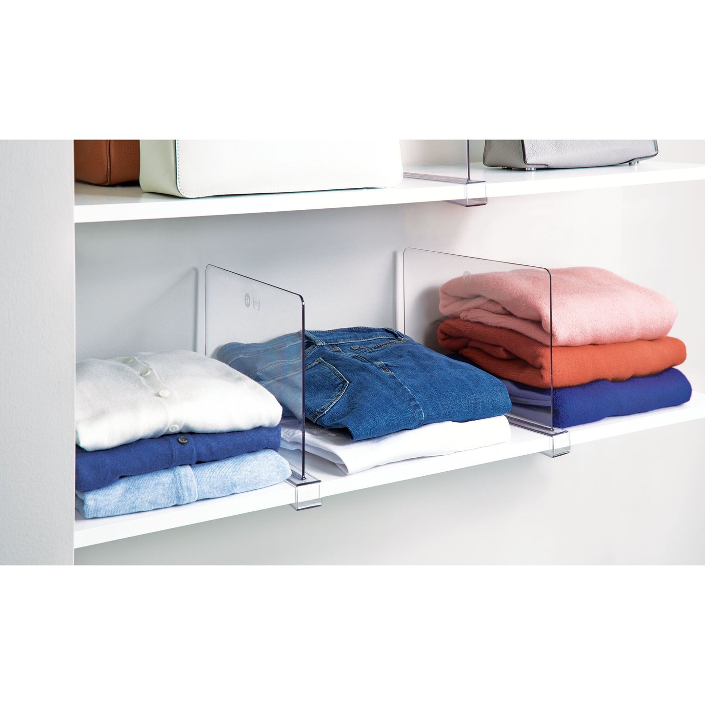 Clear acrylic shelf dividers with folded clothes in a closet