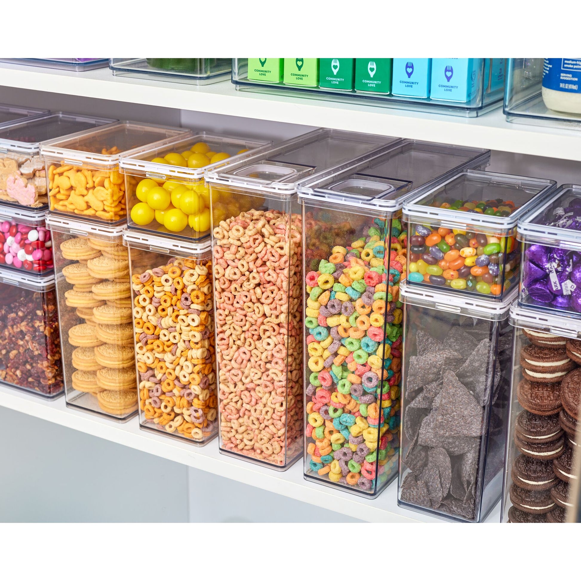 Assorted colorful snacks in transparent containers on a shelf.
