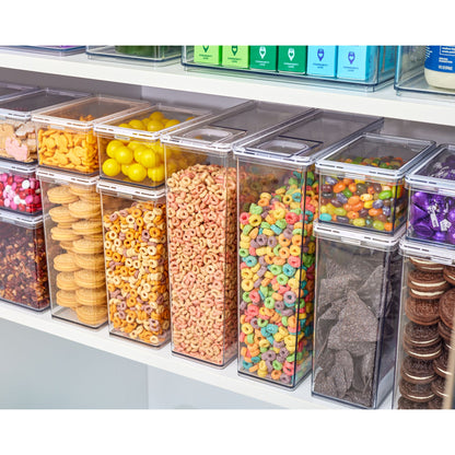 Assorted colorful snacks in transparent containers on a shelf.