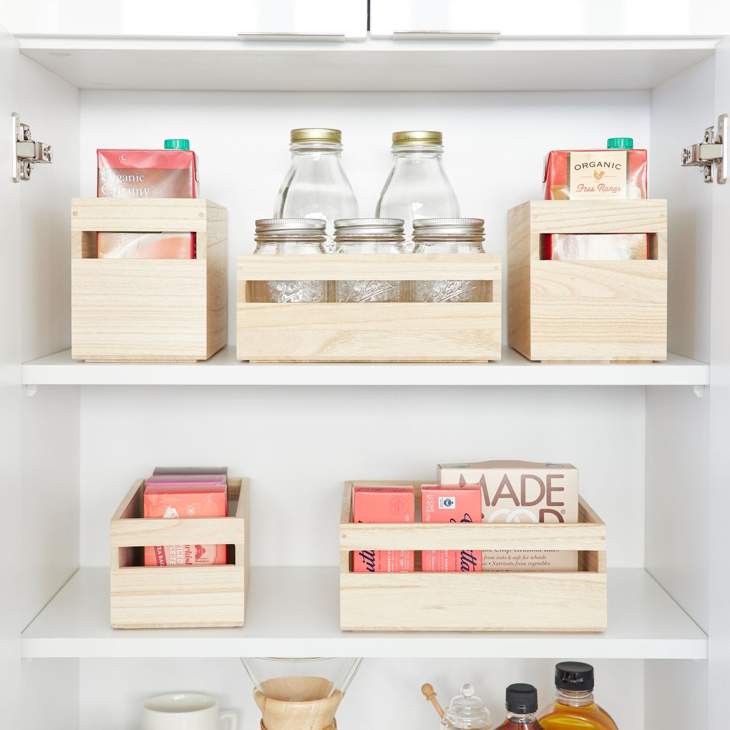 Wooden storage boxes on shelves with jars and containers