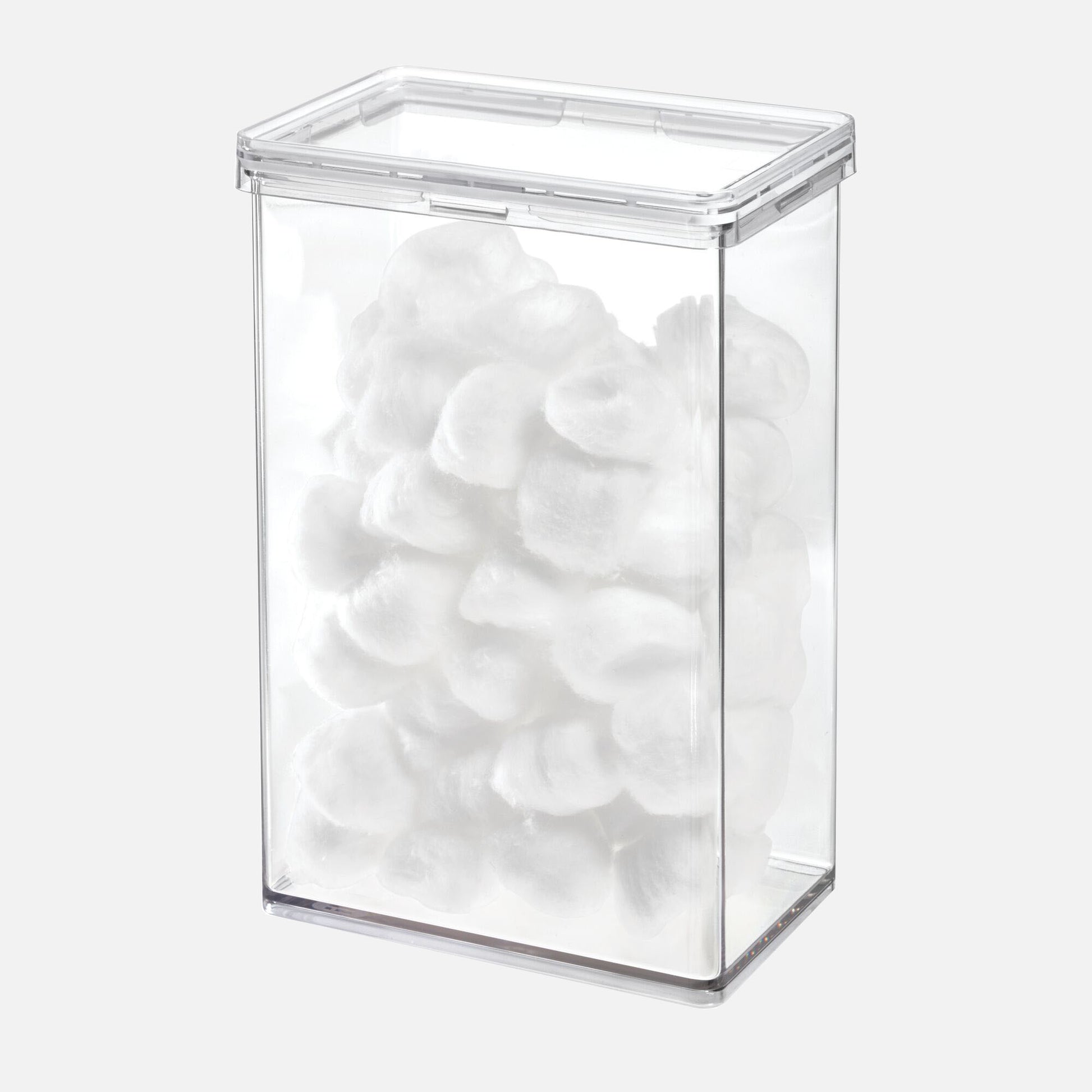 Clear rectangular container filled with white cotton balls on a white background