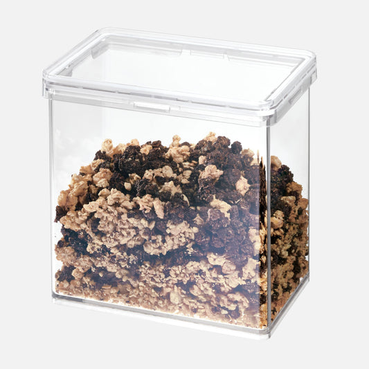Clear cube container filled with a mix of brown and black materials on a white background