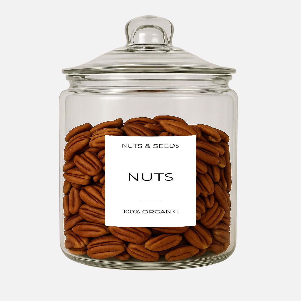 Glass jar filled with pecans labeled 'Nuts & Seeds' on a white background